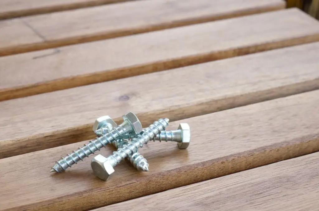 Tornillos de acero sobre una tarima de madera exterior
