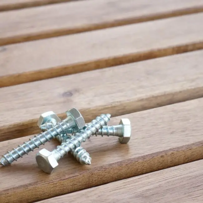 Tornillos de acero sobre una tarima de madera exterior